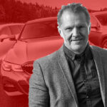 En man står framför en grupp bilar. (AI text)