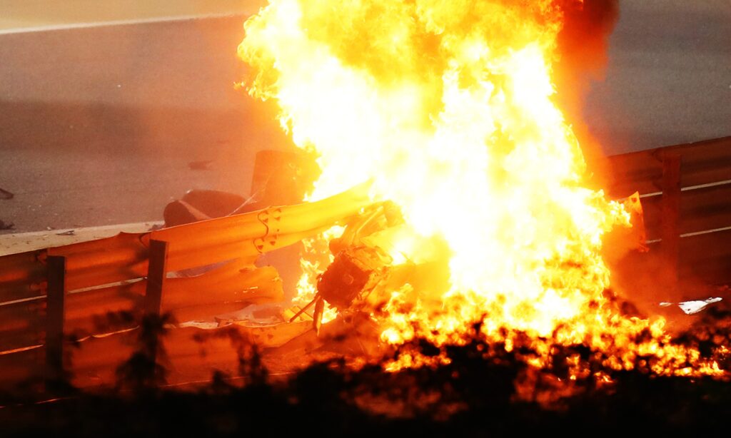 En racebil brinner på banan under natten. (AI text)