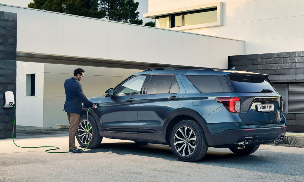 En man laddar sin bil i en garage. (AI text)