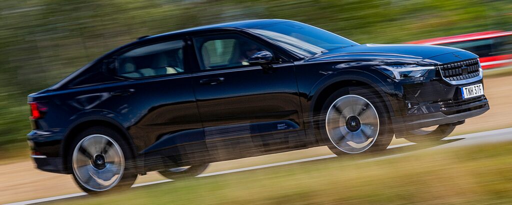 En svart Volvo E-Tron kör längs en landsväg. (AI text)