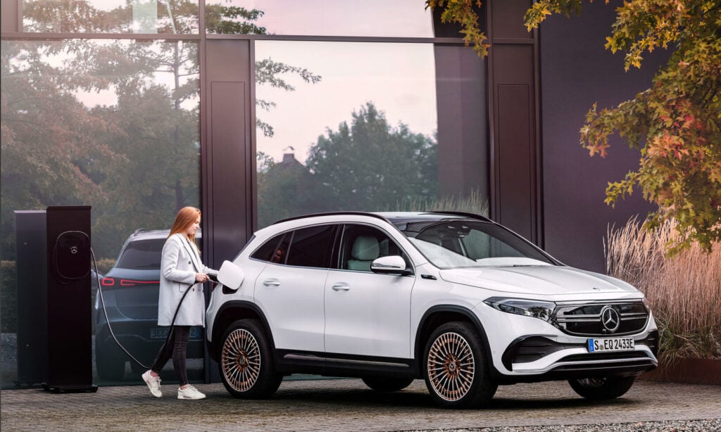 En kvinna står parkerad bredvid en Mercedes-Benz SUV. (AI text)