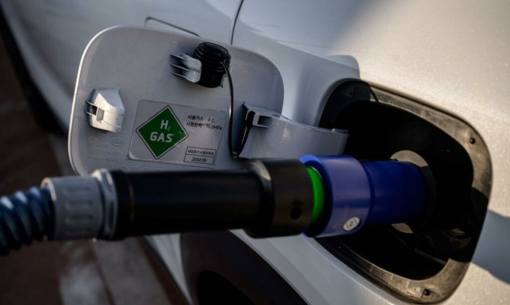 En vit bil är uppkopplad till en elladdare. (AI text)