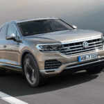 Volkswagen Touareg körs längs vägen. (AI text)