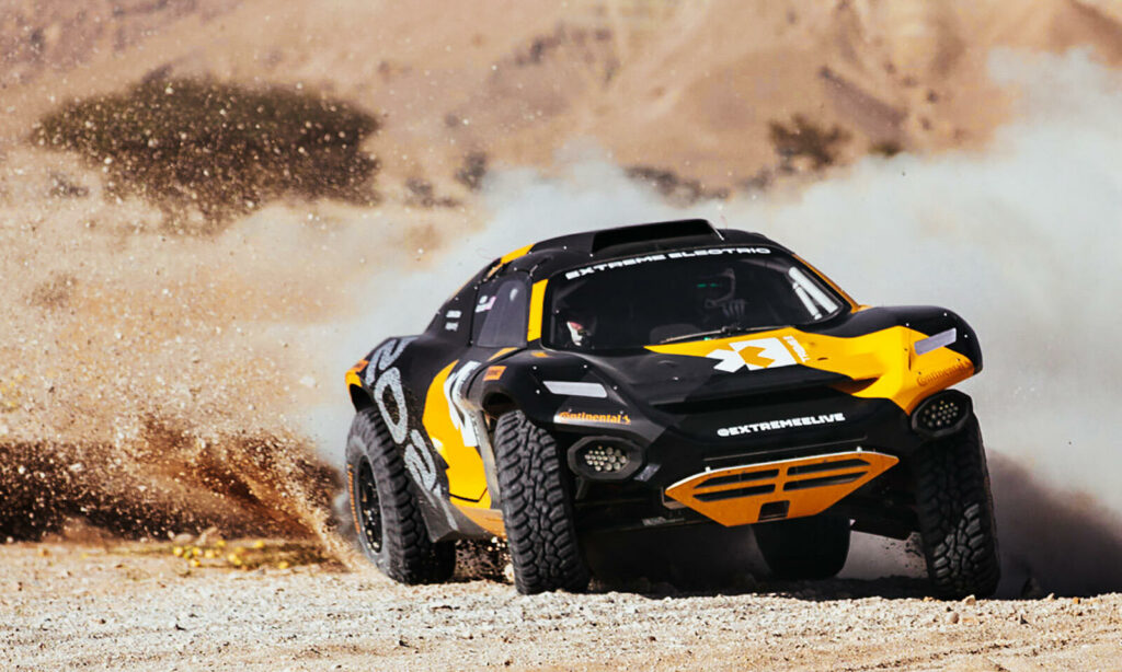 En gul och svart terrängbil kör genom öken. (AI text)