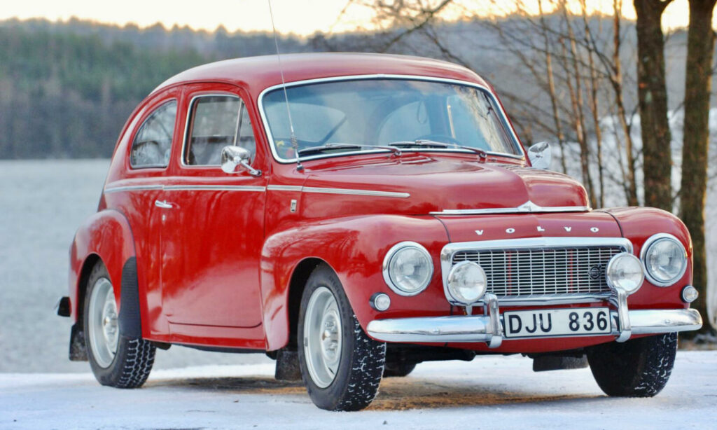 En röd bil parkerad i snön (AI text)