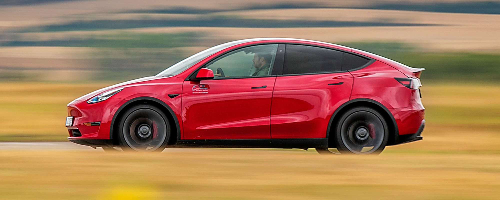 En Tesla Model Y kör på en väg. (AI text)