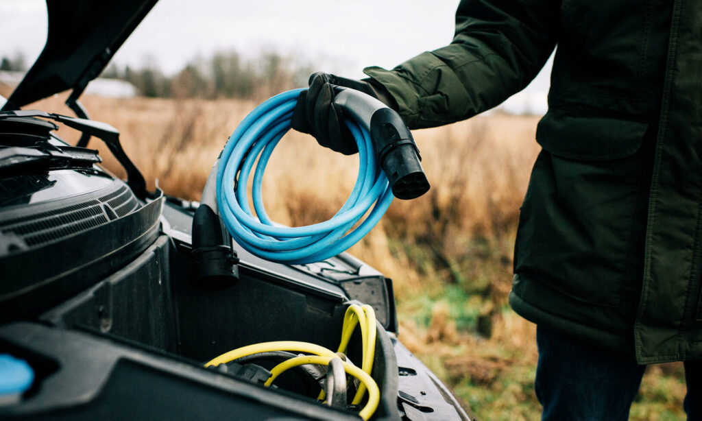 En man monterar en batteri i hans bil. (AI text)