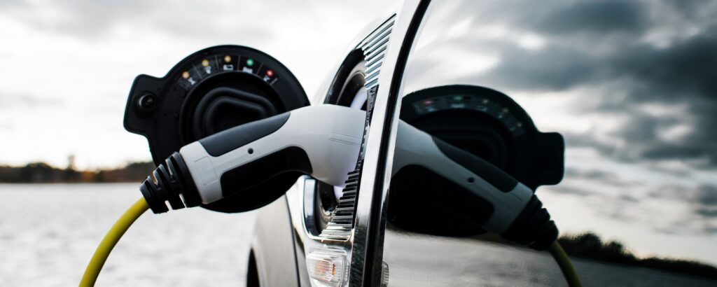 En bil är uppkopplad till en elladdare. (AI text)