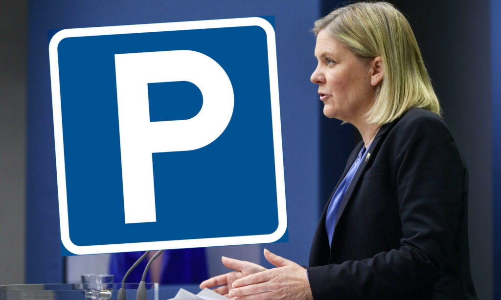 En kvinna talar vid ett podiet framför en parkeringskolumn. (AI text)