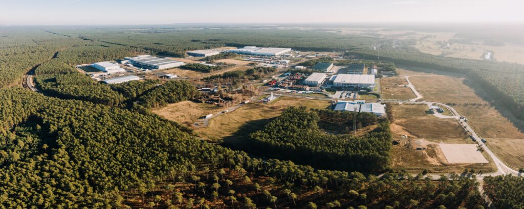 Luftbild över en fabrik i skogen (AI text)