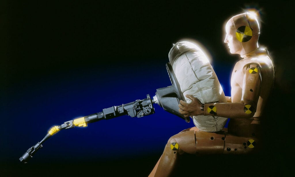 En man sitter på en stol med en ficklampa. (AI text)