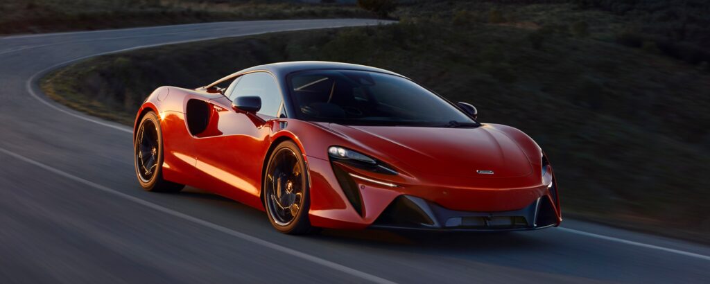 En röd McLaren SC superbil kör längs en krökt väg. (AI text)