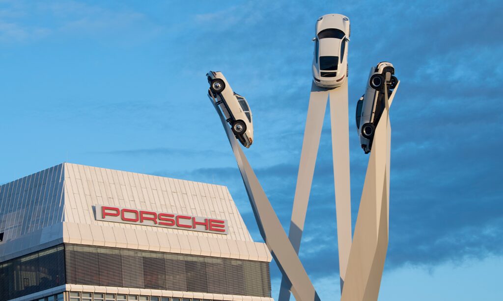 En Porsche-bil monterad på en ställning framför ett byggnad. (AI text)