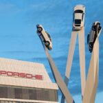 En Porsche-bil monterad på en ställning framför ett byggnad. (AI text)