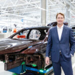 En man står inför en bilmonteringslinje. (AI text)