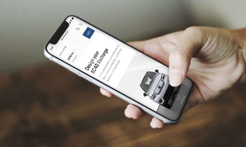 En person håller i en smartphone med bilförsäljningsappen öppen. (AI text)