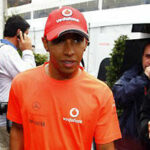 en racerförare och en mekaniker pratar med journalister (AI text)