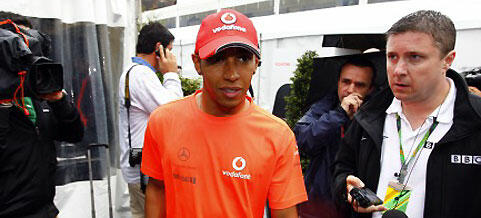 en racerförare och en mekaniker pratar med journalister (AI text)