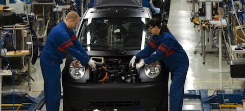 Två män arbetar på en bil i en fabrik. (AI text)