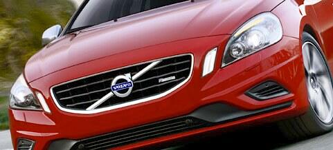 En röd Volvo S60 kör nedför en väg. (AI text)