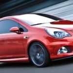 En röd bil kör på en bana. (AI text)