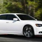 En vit Chrysler 300 kör på en bana. (AI text)