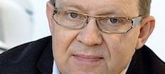 En man i glasögon tittar på kameran. (AI text)