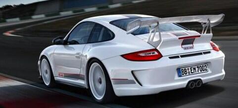 En vit Porsche 911 GTS kör på en bana. (AI text)