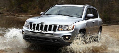 Jeep Compass kör genom en smutlig område. (AI text)
