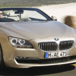 BMW 6-serie cabriolet kör på vägen (AI text)