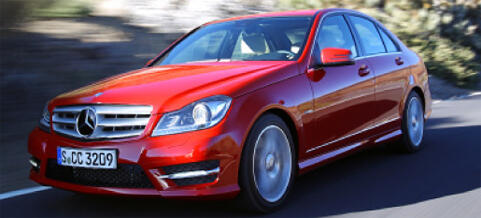 En Mercedes C-klass sedan kör nerför en bergsväg. (AI text)