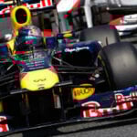 Personer i en Red Bull-racingbil under Formel 1-stallet (AI text)