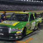 En racebil repareras på natten. (AI text)