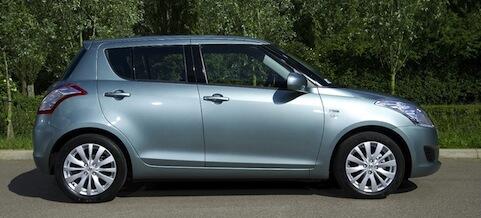 En silverfärgad Suzuki Swift parkerad på en parkeringsplats. (AI text)