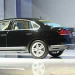 En man står vid ett podie och talar om en bil. (AI text)