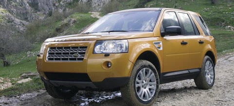 En Land Rover LR4 kör nedför en smutstig. (AI text)