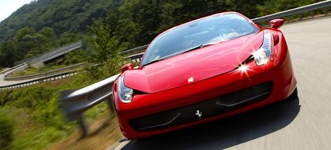 En röd Ferrari 458 Italia kör nedför en bergsväg. (AI text)