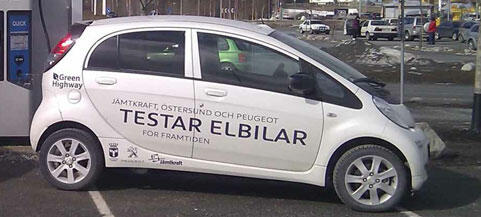 En vit bil parkerad i en parkeringsplats (AI text)