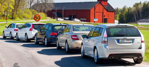 En rad bilar parkerade vid en landsväg. (AI text)