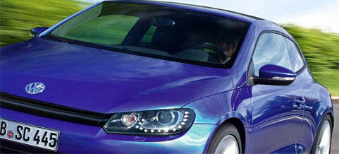 En blå Volkswagen Eos kör nerför vägen. (AI text)