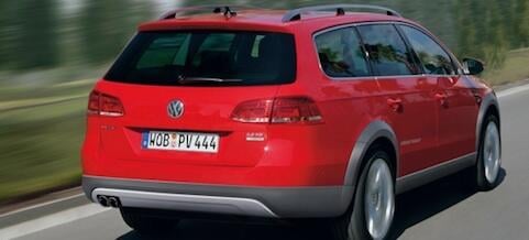 En röd Volkswagen-jeep kör nerför en väg. (AI text)