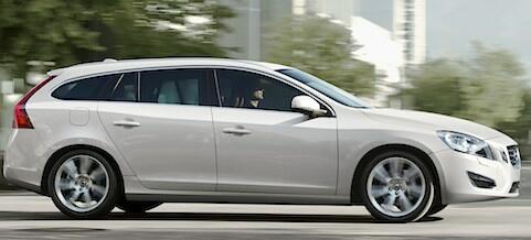 En vit Volvo V60 kombi kör längs en stadsgata. (AI text)