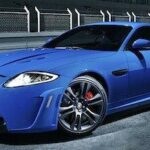 En blå Jaguar XKR-sportsbil parkerad på en racebana. (AI text)