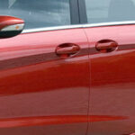 En röd Ford Fusion parkerad vid vägkanten. (AI text)