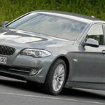 BMW 5-serie sedan körande på en landsväg (AI text)