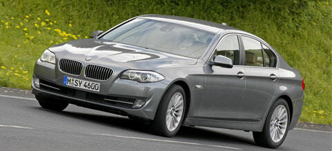 BMW 5-serie sedan körande på en landsväg (AI text)
