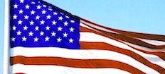 En amerikansk flagga fladdrar i vinden. (AI text)