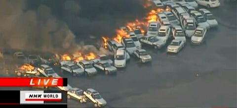 En brand sprider sig över en biltippeling. (AI text)