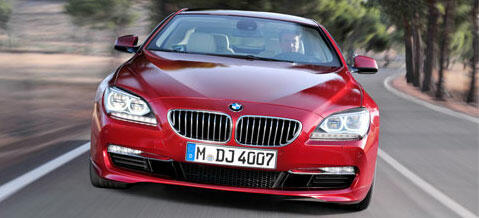 BMW 6-serie Gran Coupé kör längs en landsväg. (AI text)