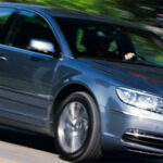 En Volkswagen Passat kör nedför en väg. (AI text)